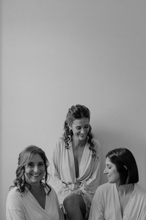 Bride and bridesmaids relaxing and laughing before the ceremony — candid pre-wedding portrait in Porto.
