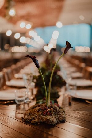 Boho-inspired table decor with long wooden tables and wild florals — wedding reception setup at The Astoria by Histórias com Alma