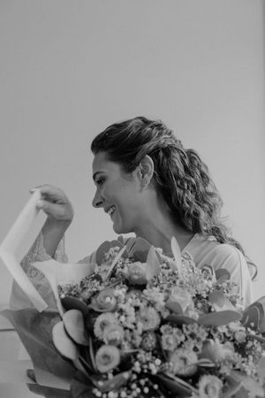 Candid moment of bride holding bouquet — floral detail shot during wedding morning in Portugal.