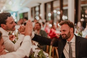 Two wedding guests share a joyful moment at an elegant indoor reception