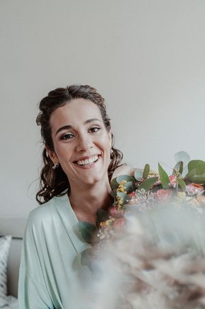 Bride laughing while holding bouquet — spontaneous portrait captured before the wedding in Porto.