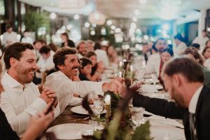 Wedding guests raise their glasses in celebration at a reception dinner under twinkling lights at The Astoria, Grijó