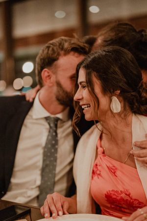 Close-up of hands clapping and rings glinting under party lights — textured detail from the wedding dance floor