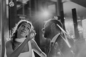Close-up of hands clapping and rings glinting under party lights — textured detail from the wedding dance floor