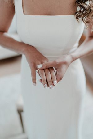 Bride holding her dress — detail photo from a boho-inspired destination wedding in Portugal.