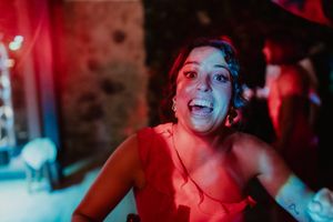 Guest singing out loud with a drink in hand — bold and carefree celebration at a destination wedding