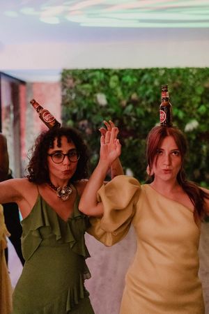 Two persons dancing at a Portugal wedding party with bottles balanced on their heads at The Astoria, Grijó, Porto.