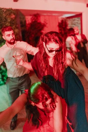 Two women dancing barefoot under party lights — raw and emotional moment during a non-traditional wedding