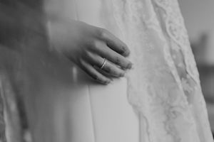 Close-up of bride’s hand on lace wedding dress — emotional detail from a Porto wedding.