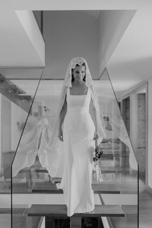 Bridal portrait adjusting hair in a quiet room — behind-the-scenes of a destination wedding in Portugal.