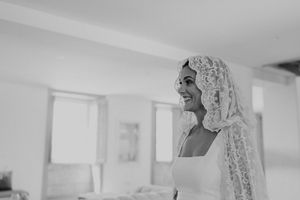 Bridal portrait adjusting hair in a quiet room — behind-the-scenes of a destination wedding in Portugal.