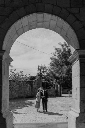 Wedding portrait under a stone arch at The Astoria venue in Porto — destination couple shoot with cinematic framing.