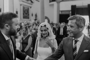Candid moment during a Portuguese wedding ceremony at The Astoria — bride smiling with guests in the background.