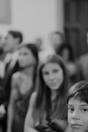 Young guest looking curiously during the ceremony — natural and unscripted wedding moments in a church near The Astoria, Porto.