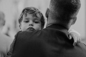 Portrait of a child looking into the camera during a wedding at The Astoria — candid family moment captured by Portugal wedding photographer
