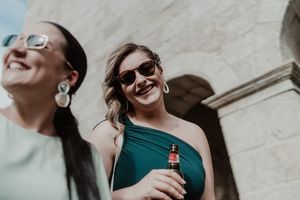 Wedding guests smiling in the sun — relaxed and spontaneous cocktail moment at The Astoria wedding venue in Portugal.