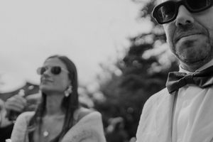 Cool wedding guest in sunglasses and bow tie — laid-back vibe from an outdoor celebration at The Astoria, Portugal.