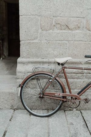 Decorative wedding bicycle by a stone wall — rustic boho wedding detail at The Astoria, Portugal.