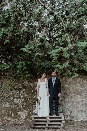 Bride standing under a boho-inspired tree arch — relaxed wedding portrait in the garden of The Astoria by Histórias com Alma.