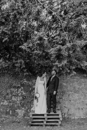 Bride standing under a boho-inspired tree arch — relaxed wedding portrait in the garden of The Astoria by Histórias com Alma.