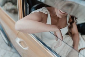 Candid portrait of the bride smiling inside the car before the ceremony — spontaneous storytelling wedding photo in Portugal.