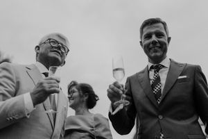 Friends toasting with drinks and posing with the couple — casual wedding portrait with energy