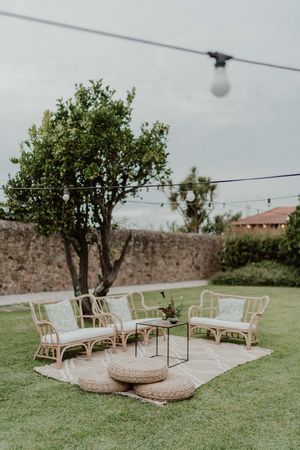 Wide shot of the couple framed by boho garden decor — cinematic wedding photo at The Astoria by Histórias com Alma