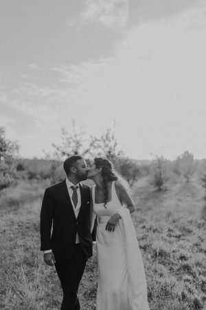 Soft close-up of the couple’s foreheads touching, surrounded by garden greenery