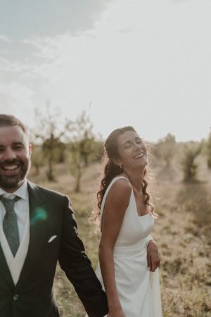 Soft close-up of the couple’s foreheads touching, surrounded by garden greenery