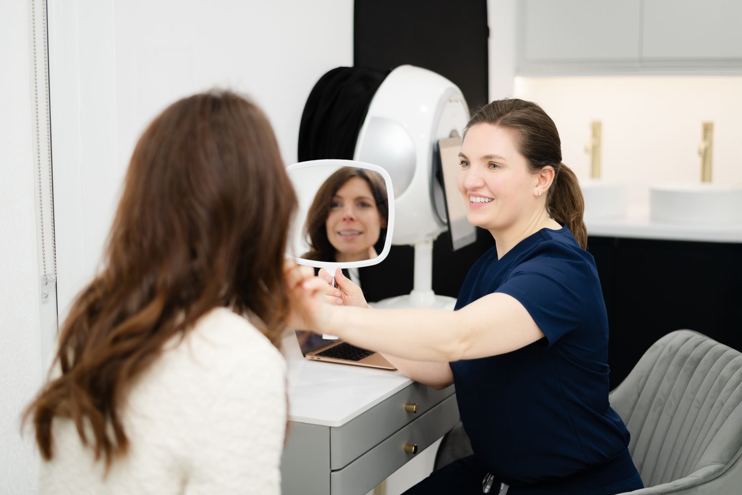 Healthcare professional operating medical imaging equipment with patient in a modern clinical setting.
