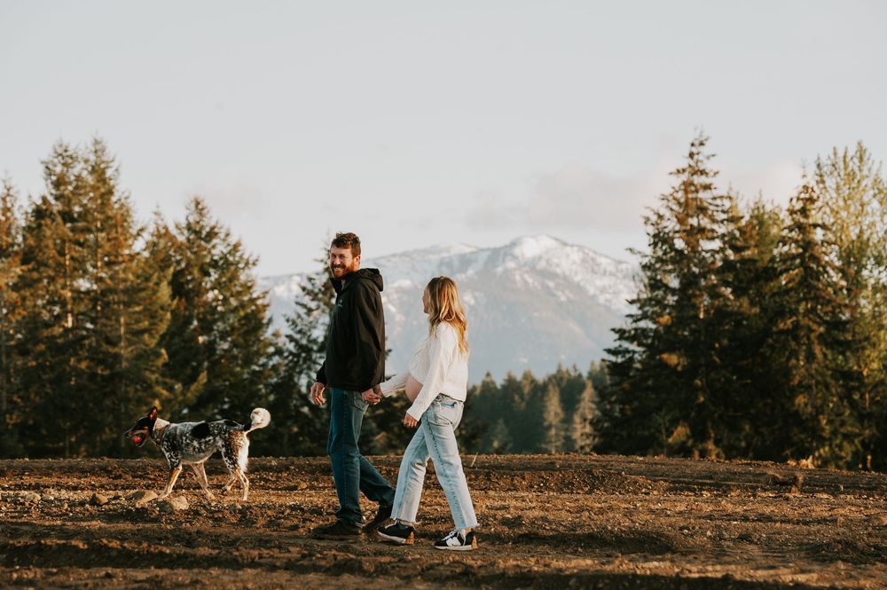 Maternity photoshoot of couple walking in front of beautiful mountain views on Vancouver island golden hour light photographer