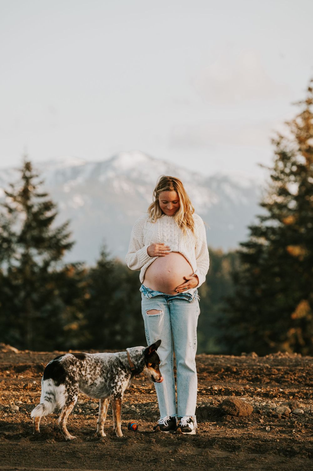 Maternity candid portrait photography pregnant woman in front of beautiful mountain views on Vancouver island golden hour light photographer