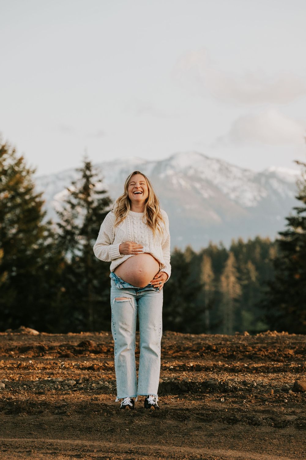 Maternity candid portrait photography pregnant woman laughing in front of beautiful mountain views on Vancouver Island photographer