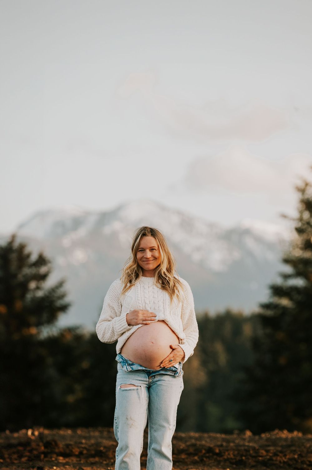 Maternity portrait photography pregnant woman in front of beautiful mountain views smile on Vancouver island golden hour light photographer