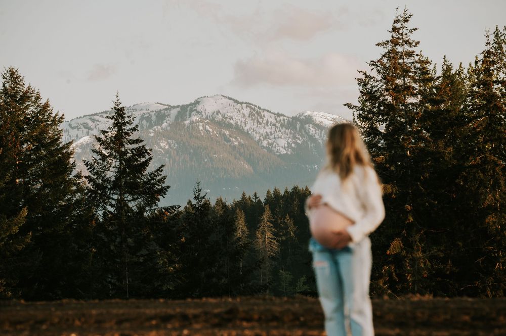 Maternity candid portrait photography pregnant woman looking at beautiful mountain views on Vancouver Island natural feeling photographer
