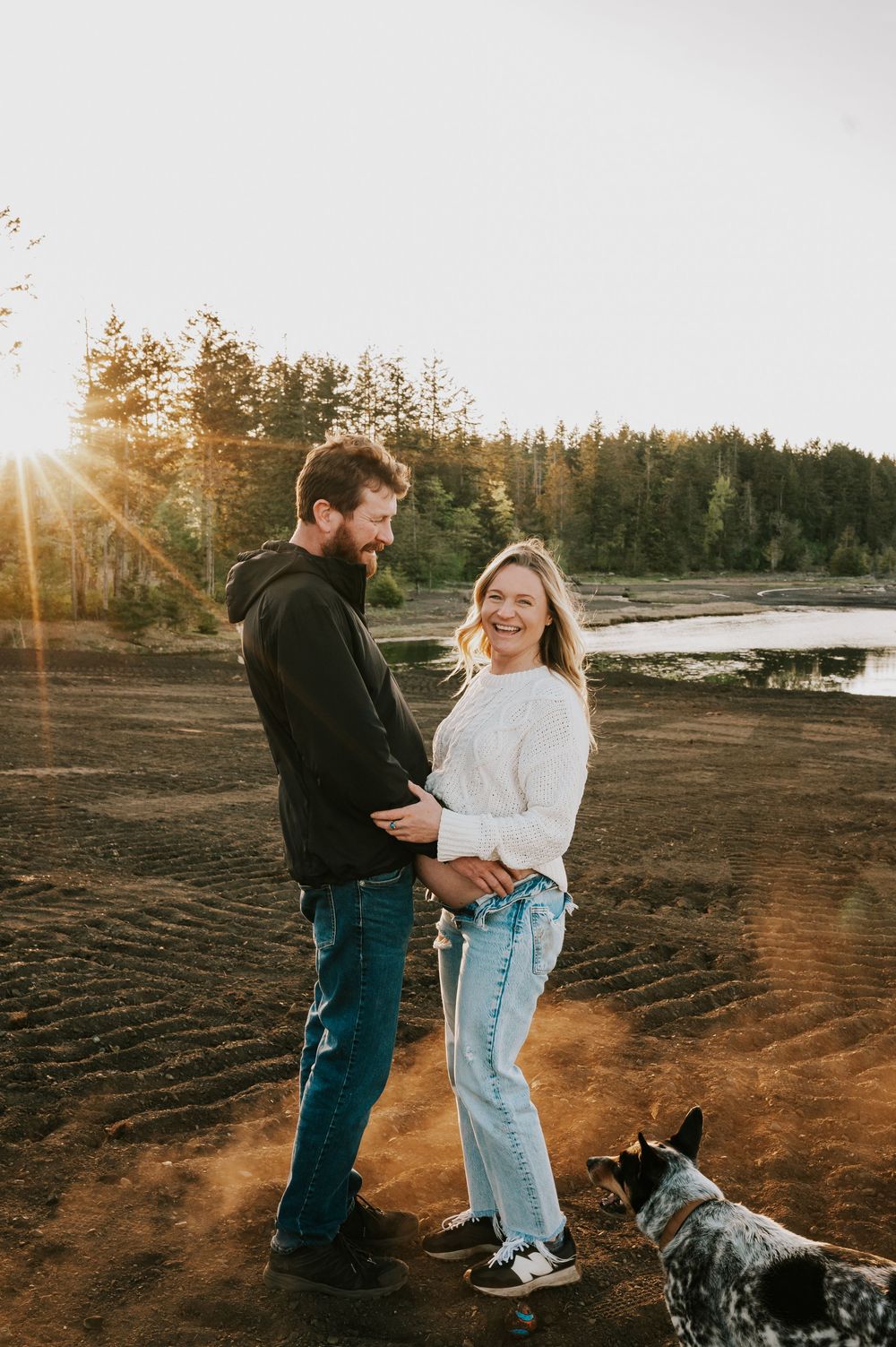 Maternity photography couple embracing on hill close to ocean dusty golden hour light beams Vancouver Island natural feeling photographer