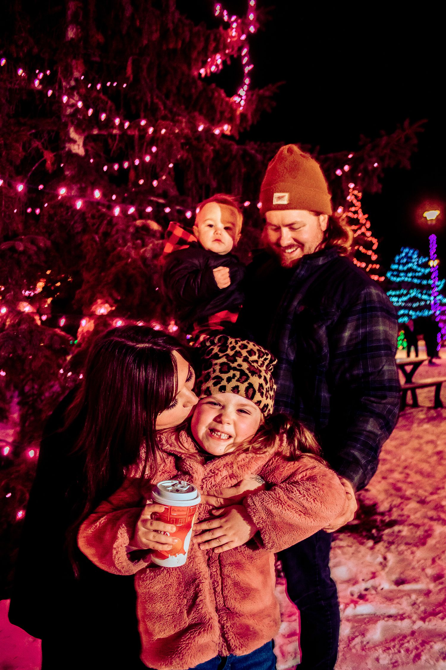 A festive nighttime scene with colorful Christmas lights and holiday decorations.