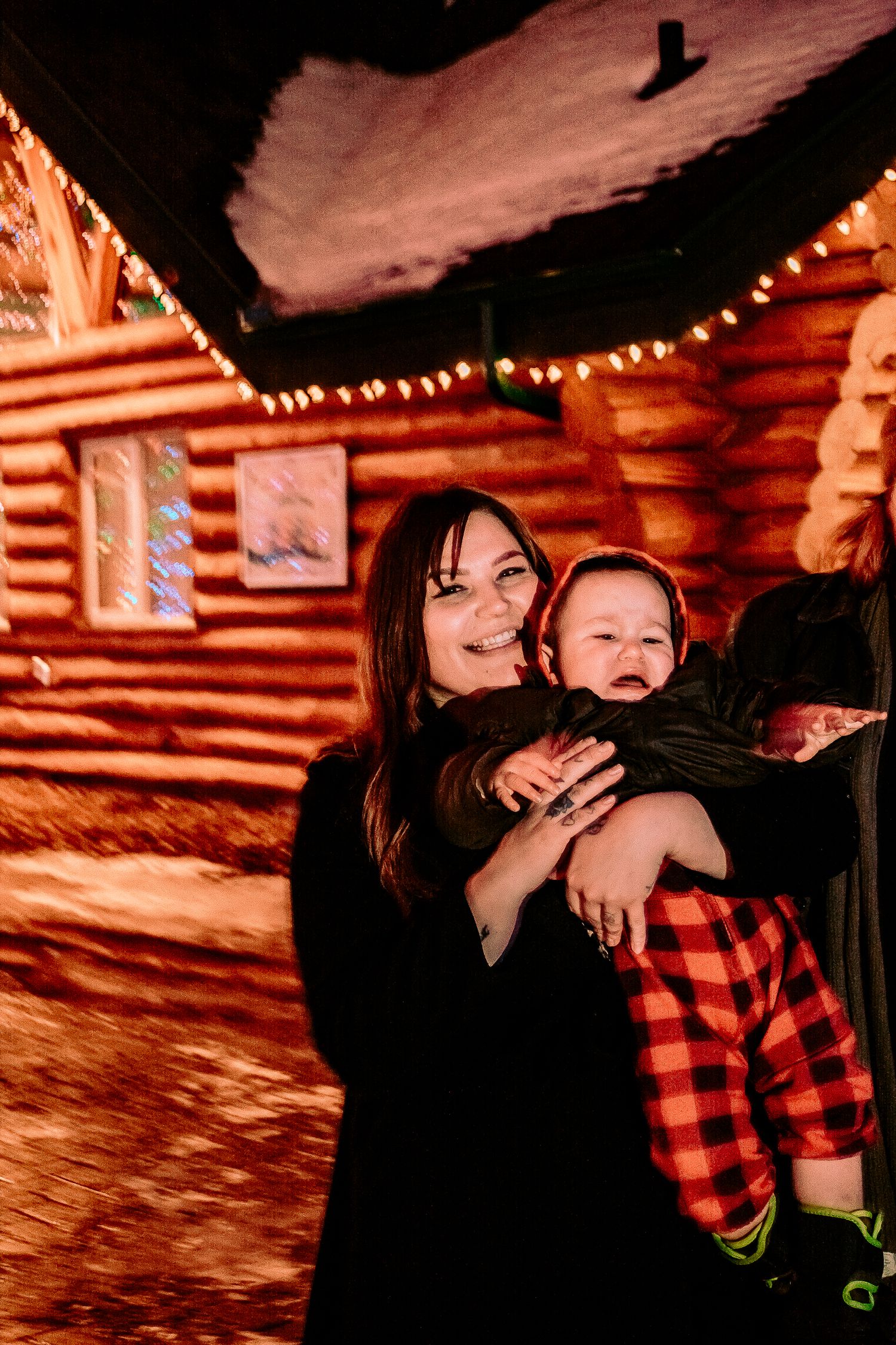 A warmly lit log cabin interior creates a festive atmosphere during the holiday season.