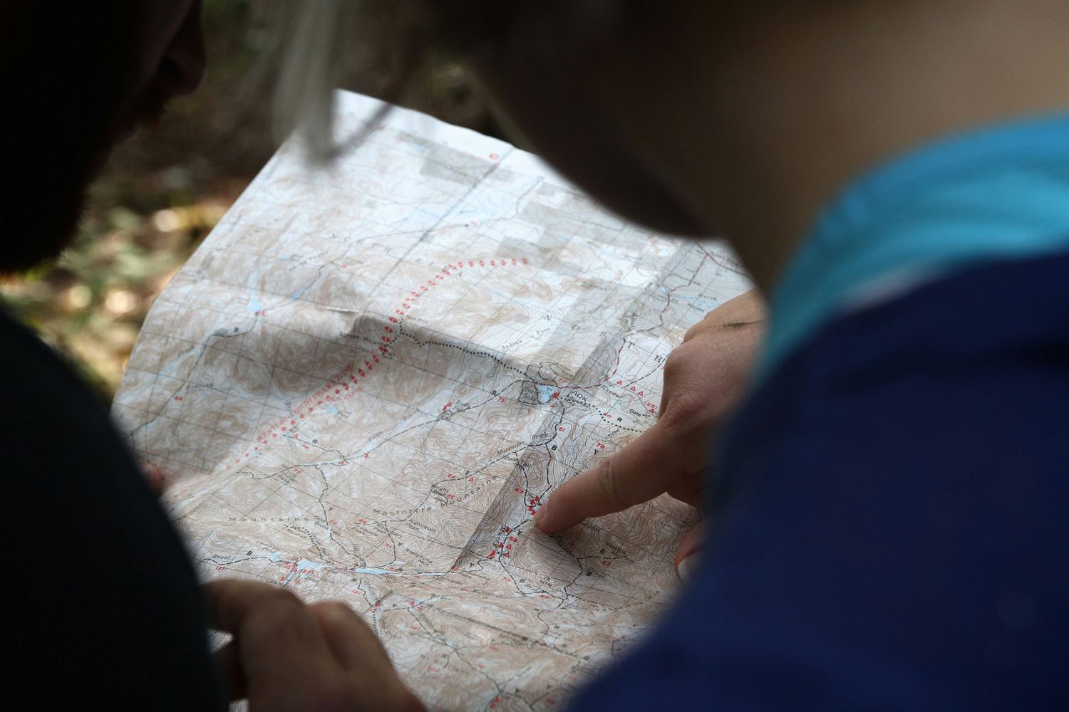 Close-up view of hands holding and examining a paper map.