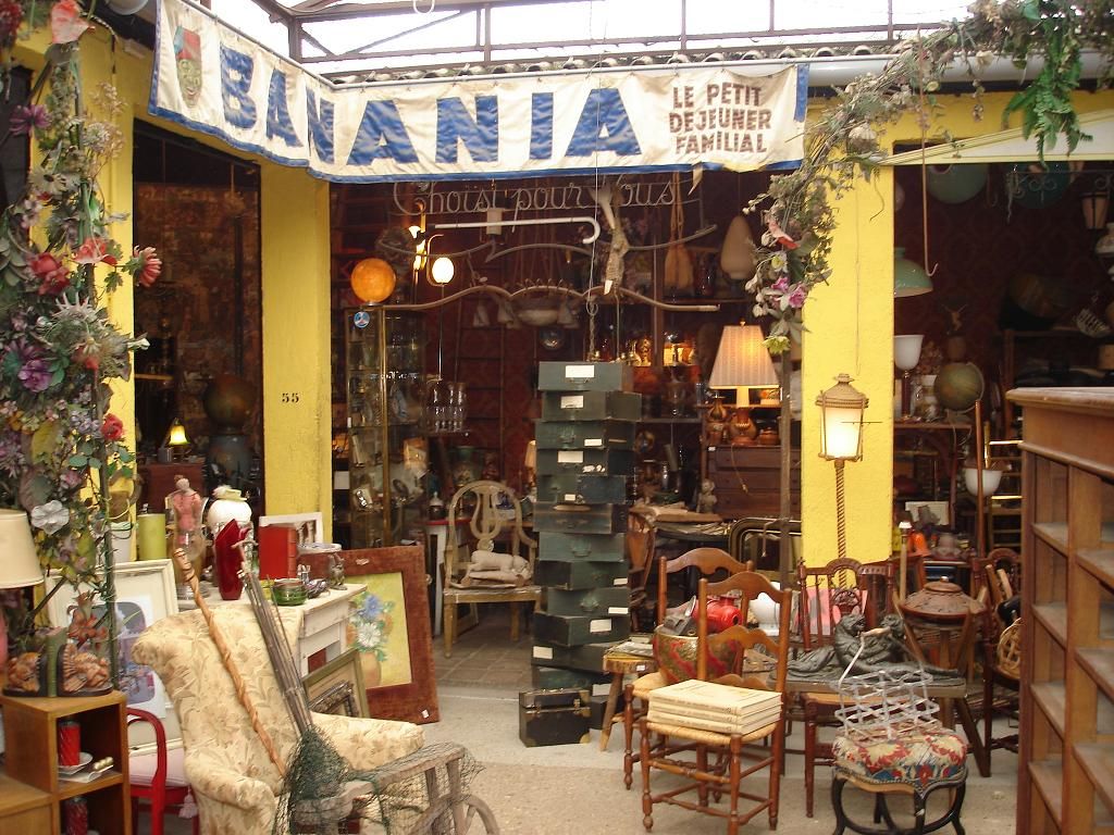 Eclectic antique shop entrance with yellow walls and vintage furniture displays.