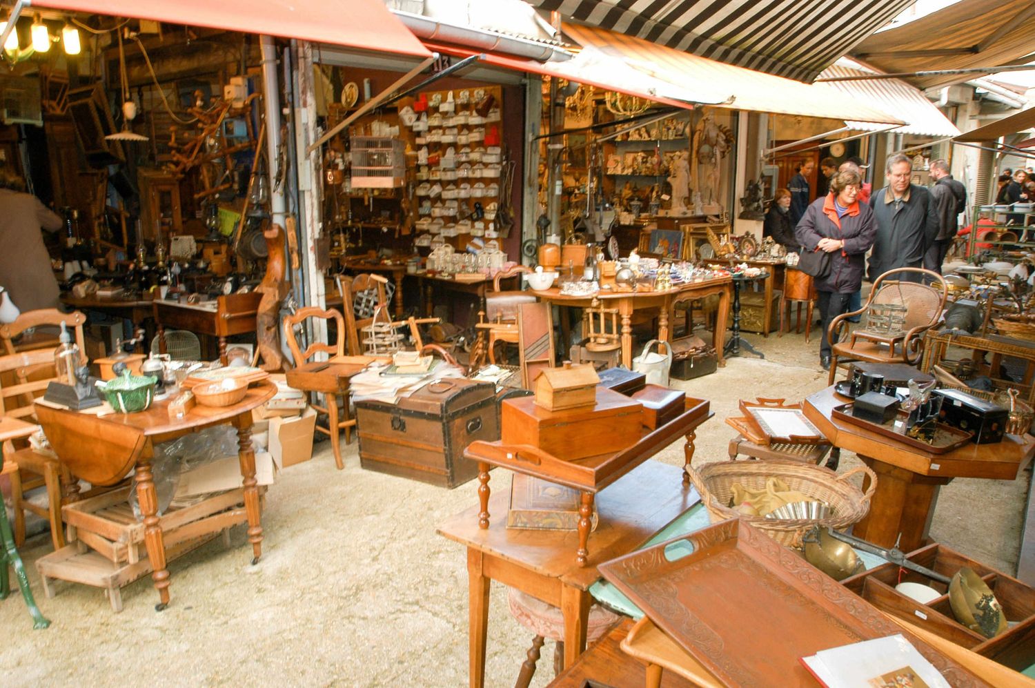 Rustic flea market stall filled with wooden furniture and vintage collectibles.