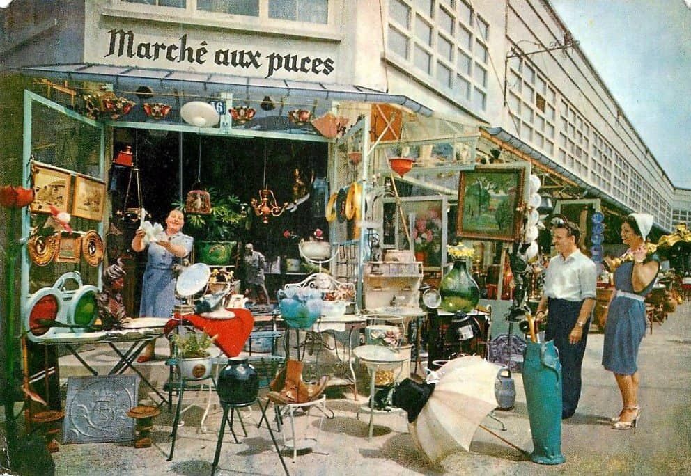 Bustling flea market scene at Marche aux Puces in Paris with vintage furniture and collectibles.