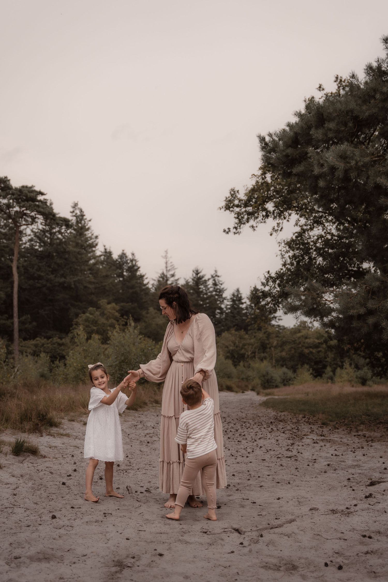 Vrolijke gezinsshoot met spelende kinderen in de natuur. Spontane en pure familieportret in de avondzon.