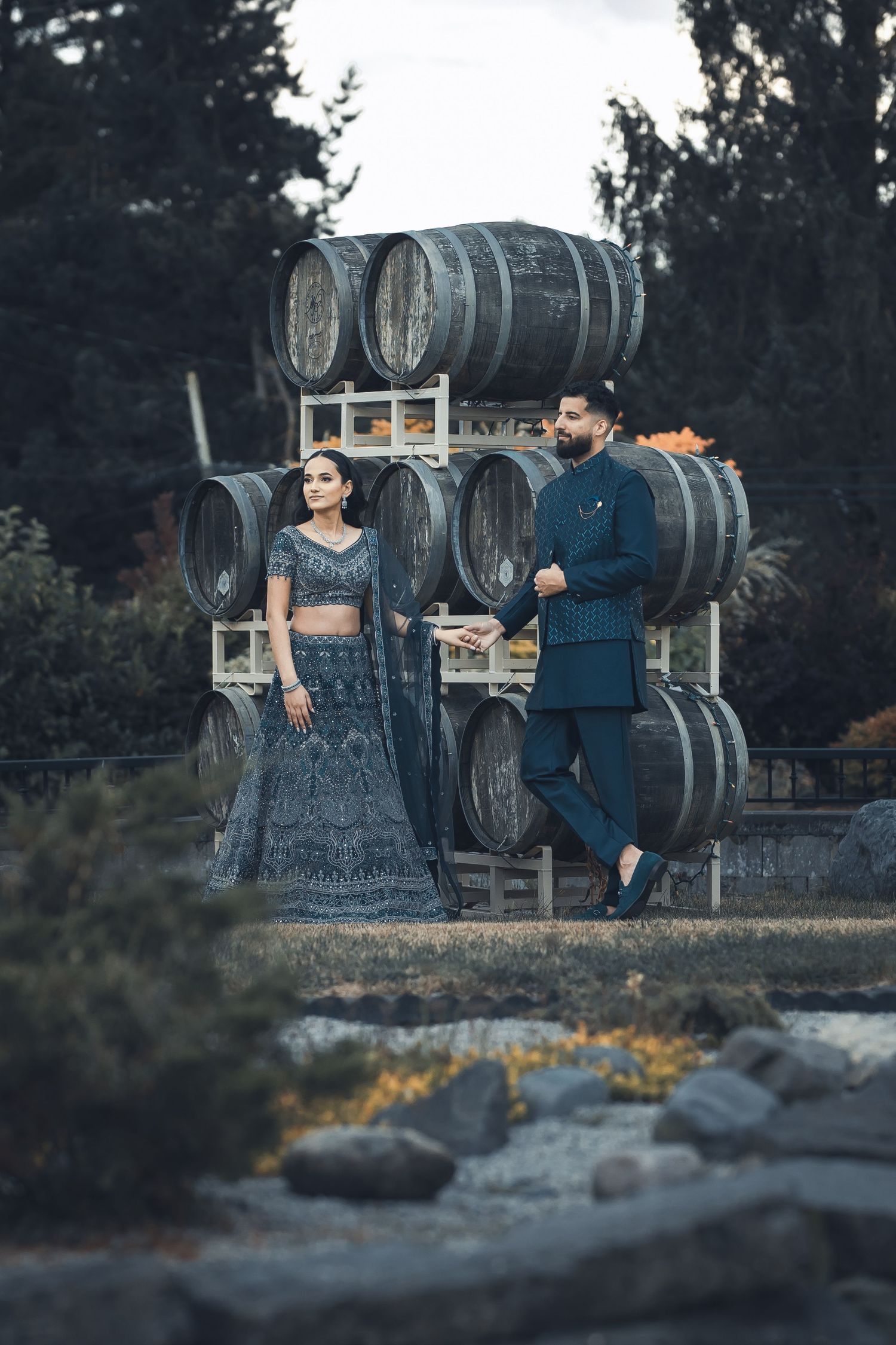 Photoshoot of a couple looking at the horizon a midst the dark aesthetic with cauldron in the background.