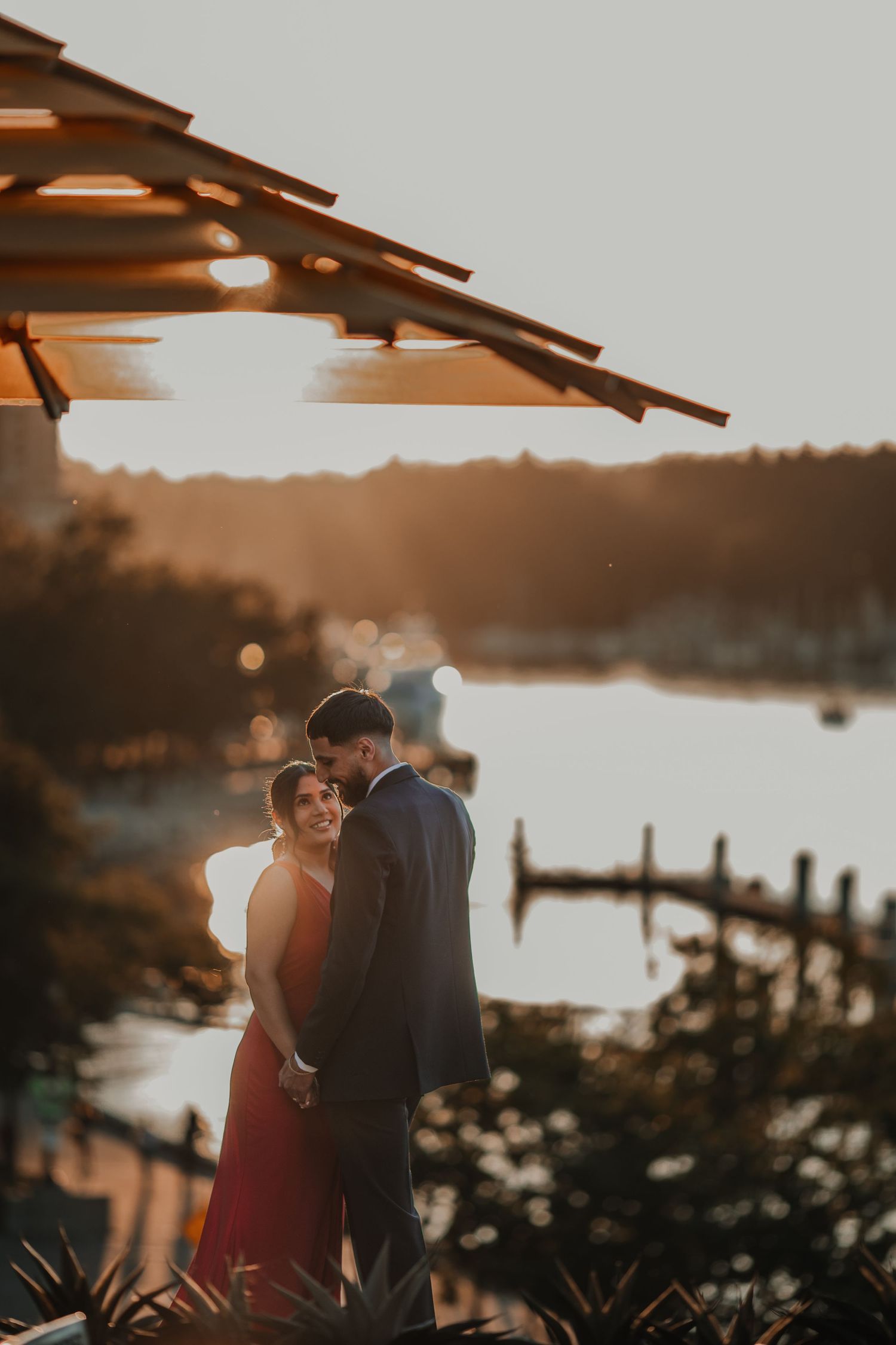 A romantic pre-wedding photoshoot of a couple at a restaurant with a stunning sunset in the background, aesthetic shoot.
