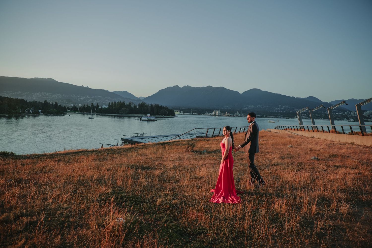 Pre-wedding photoshoot of couple holding hands looking at the horizon.