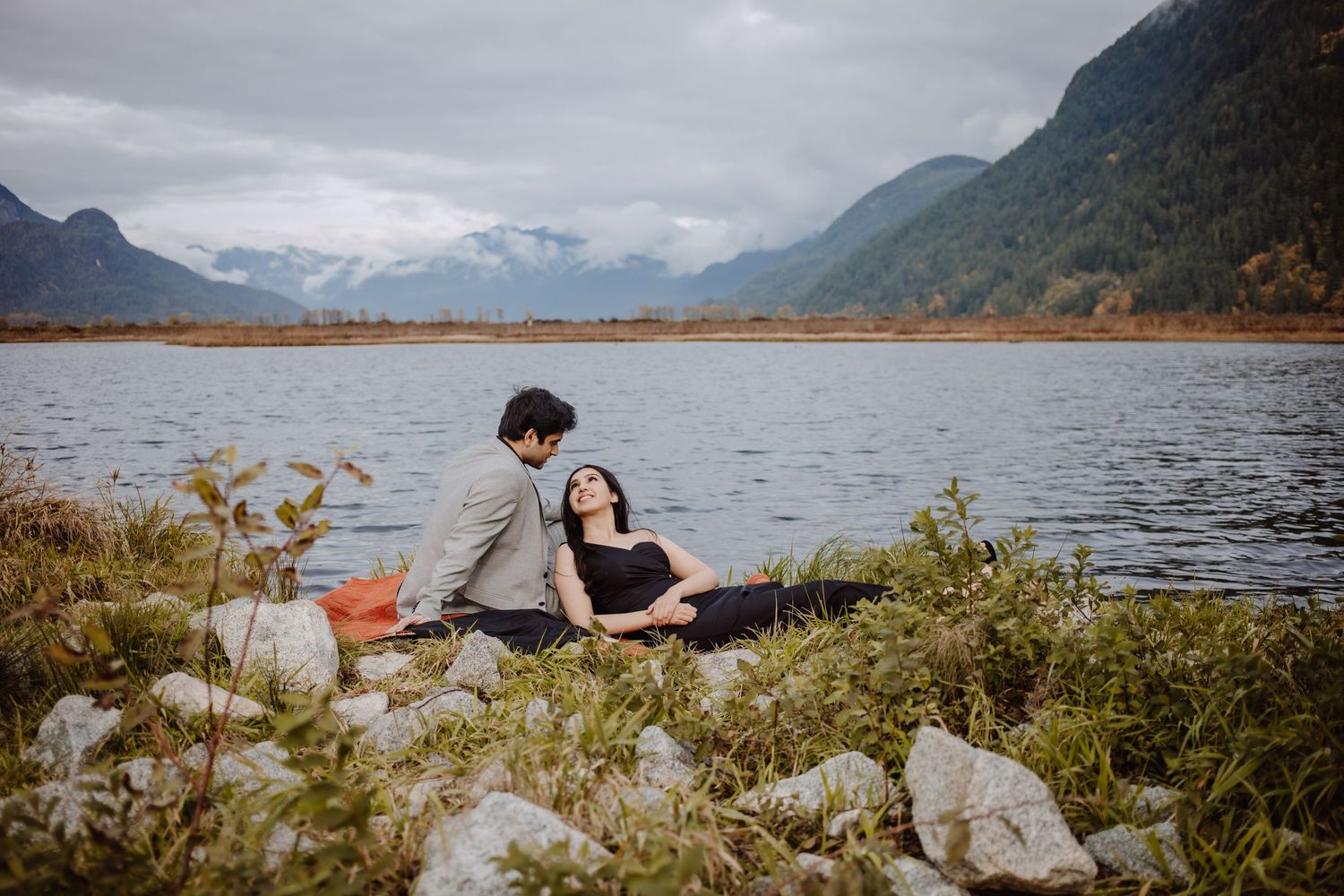 pre-wedding photoshoot of couple leaning on each other on a riverbank midst the greenery, aesthetic photoshoot.