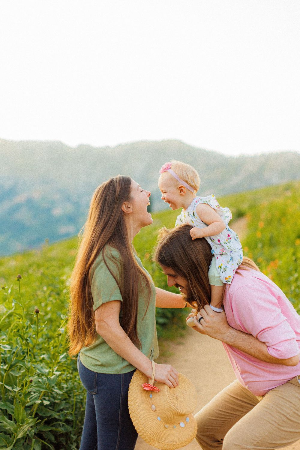 Family enjoying a joyful moment together in a scenic Albion Basin mountain meadow during golden hour.