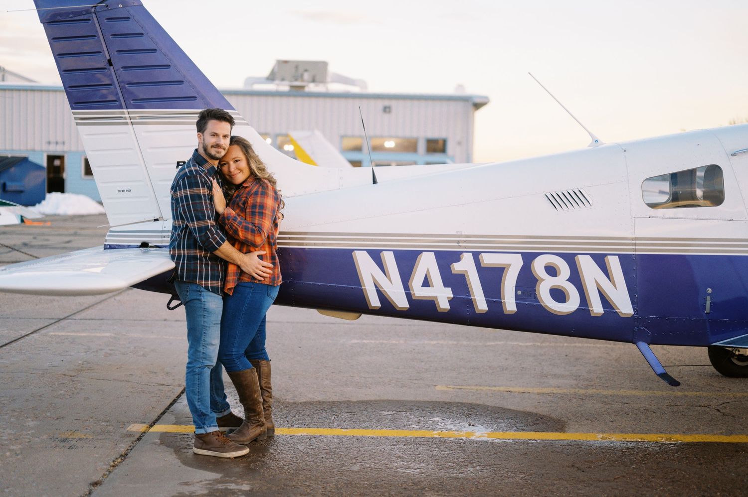 A couple poses next to a small private aircraft with registration number N4178N.