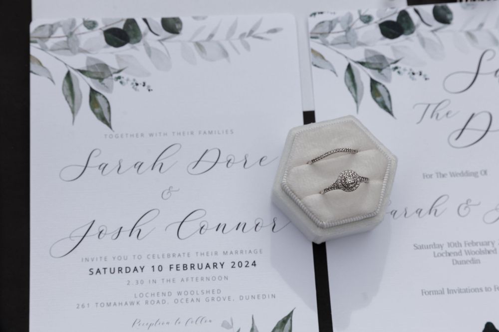 Wedding invitation with watercolor greenery design and hexagonal ring box.